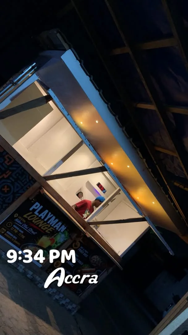A cook working inside the kiosk at 9:34 PM in Accra